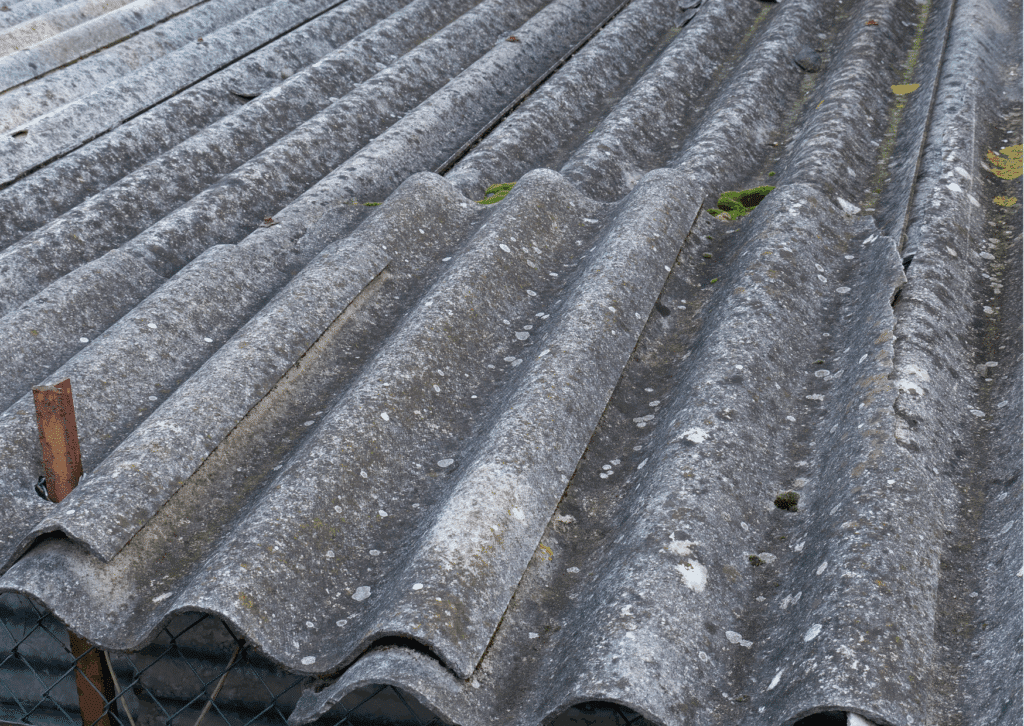 Detailed close-up of an aging corrugated asbestos roof on a Brisbane home, showing visible cracks, flaking, discoloration, and chalky texture.