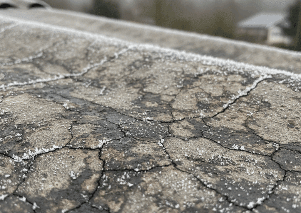 Winter Is the Best Time for Roof Inspections: How to Spot Asbestos Damage Early 3 Detailed close-up of an aged asbestos cement roof tile showing hairline cracks, water stains, and frost buildup, conveying material fragility.